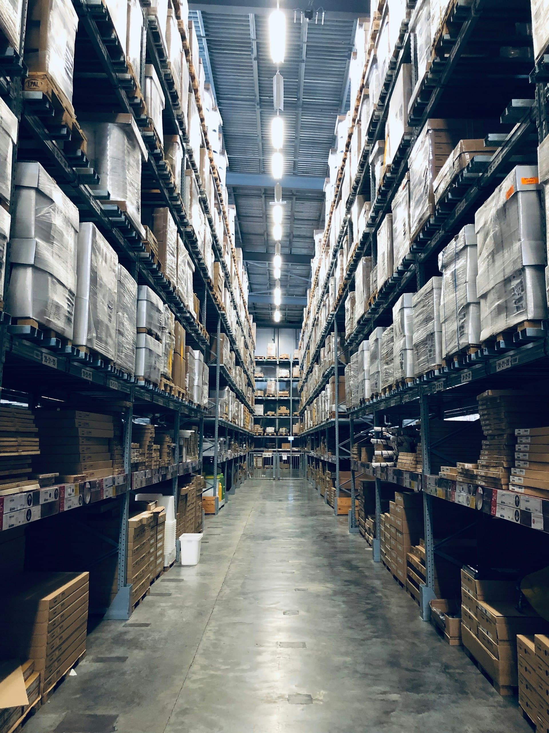 Long logistics aisle between blue warehouse racks